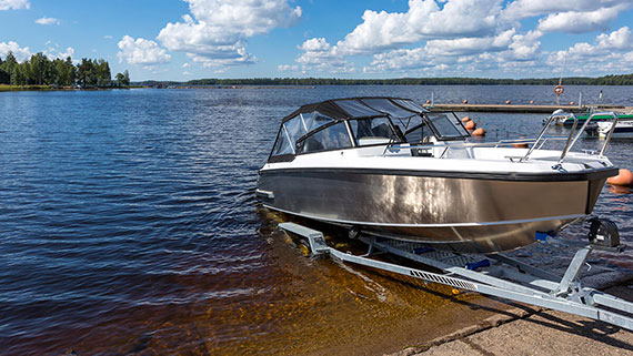 Pickup truck at the end of water-a boat ramp with boat in water