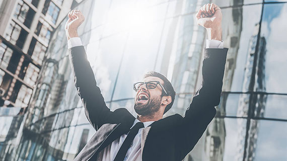 A joyful woman with arms up and confetti raining down