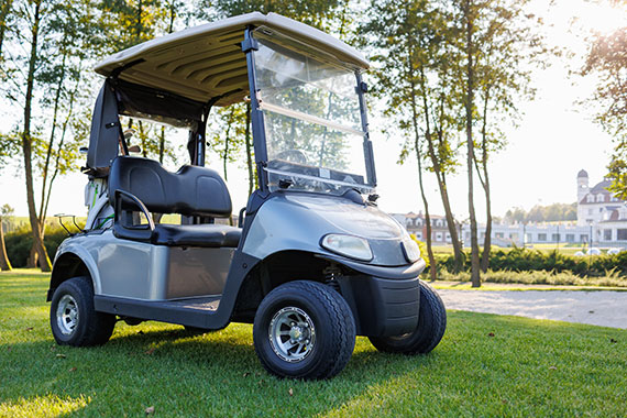 A golf cart parked on grass.
