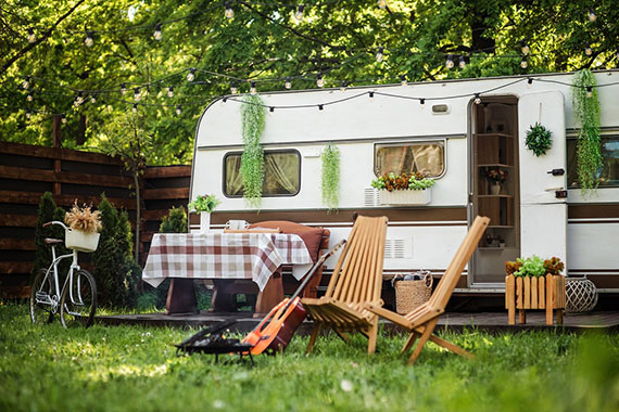 A travel trailer all set up with lights and outdoor table